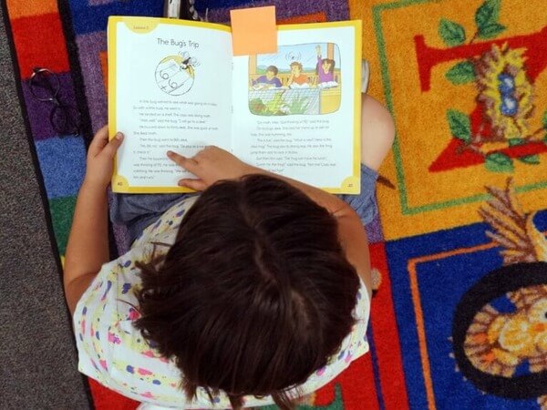 Eagle eye view of a child reading a book.