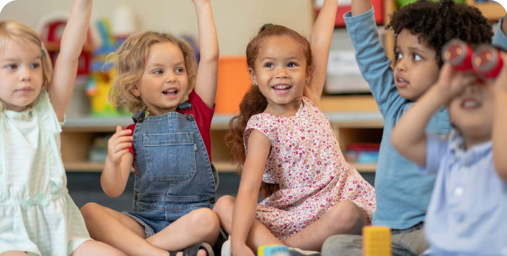 Multiple children raising their hands in excitement.