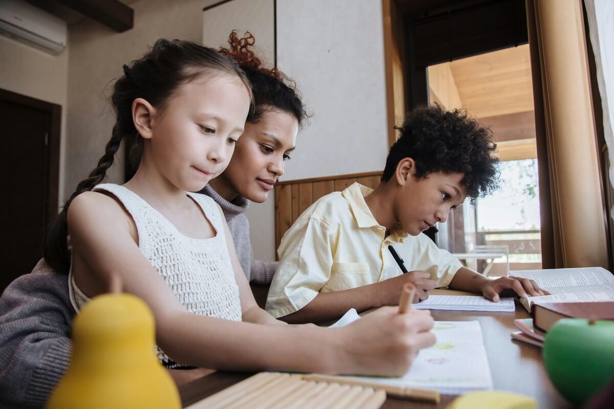 Mother helping her children with homework.