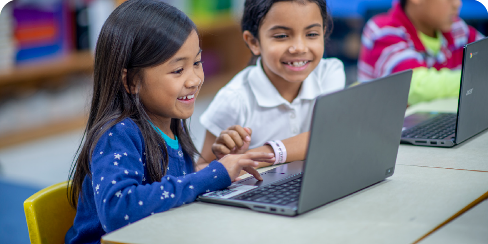 Two students utlizing a computer.