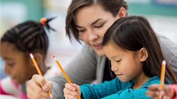 Teacher helping student in class.