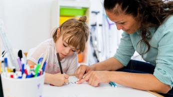 Teacher showing student how to write