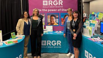 Four women standing in front of RGR tradeshow table.