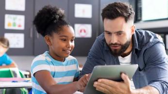 Teacher helping student with handheld device