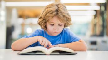 Male student reading a book.