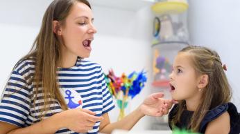 Woman and young girl practicing oral language.