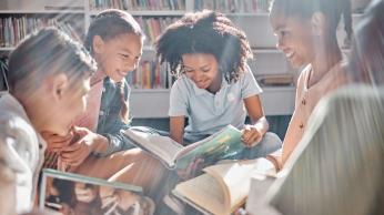 Children reading books in classroom.