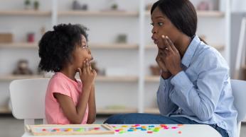 Woman and young girl practicing oral language.