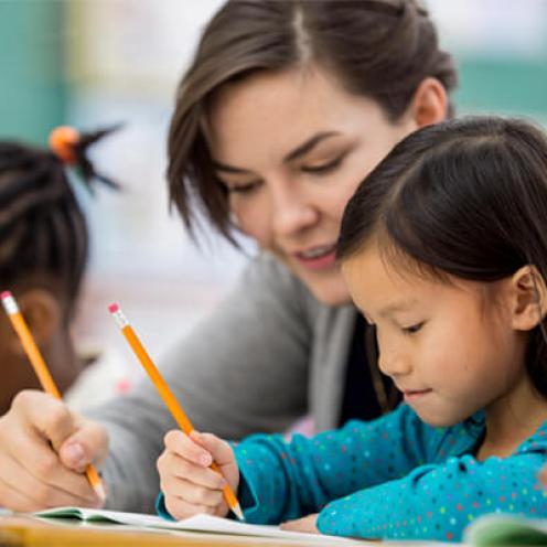 Teacher helping student in class.