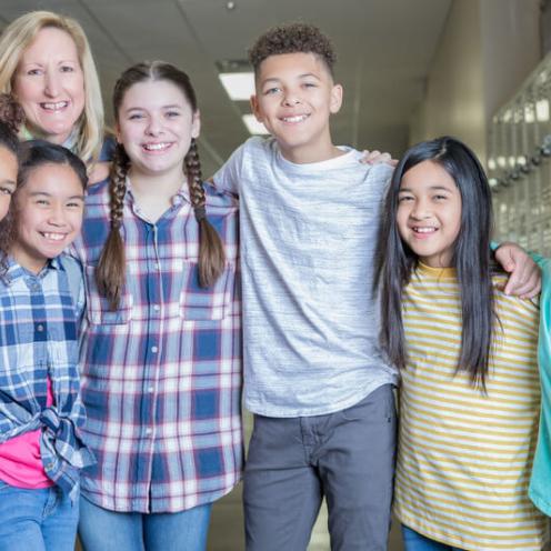 Teacher with students in hallway.