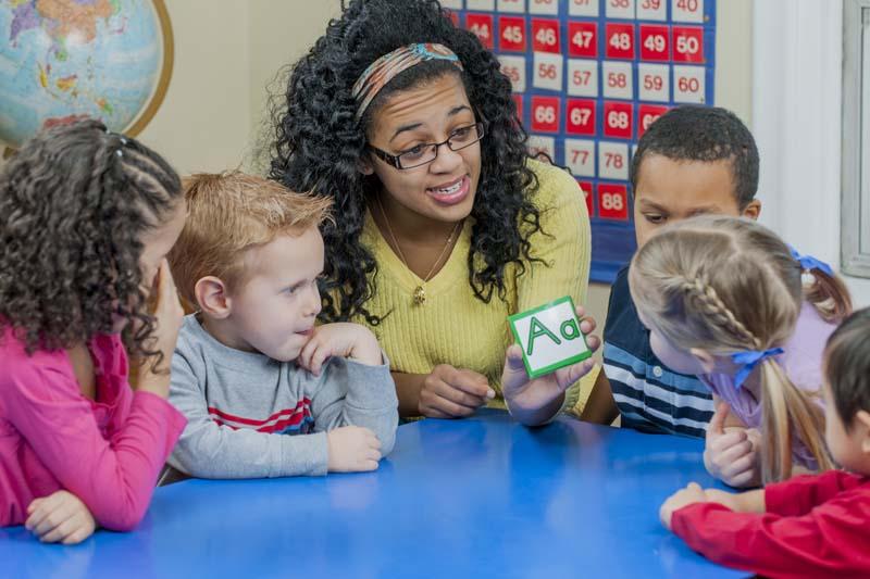 teacher showing letter A to preschoolers