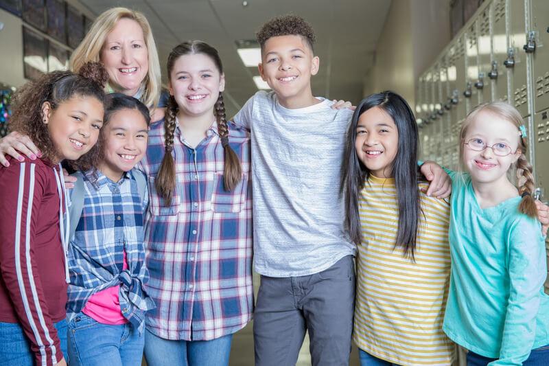 Teacher with students in hallway.