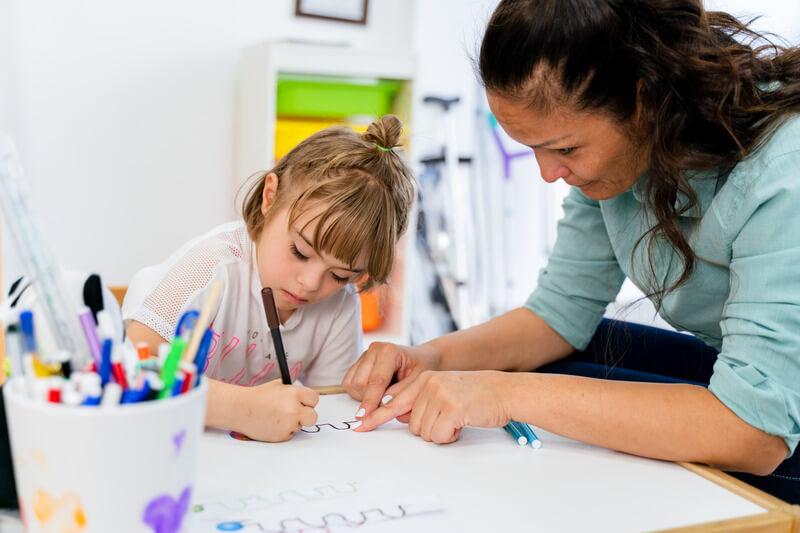 Teacher showing student how to write