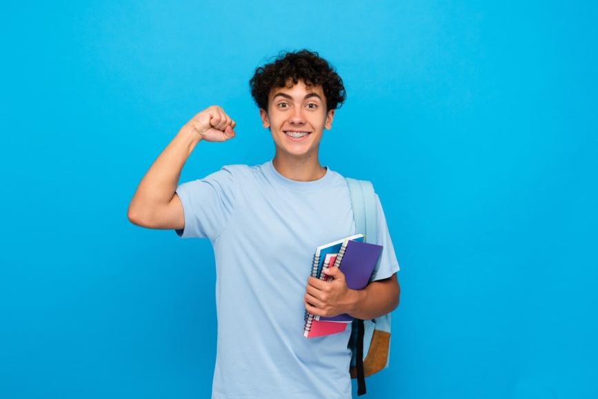 Adolescent reader making a muscle and holding books.