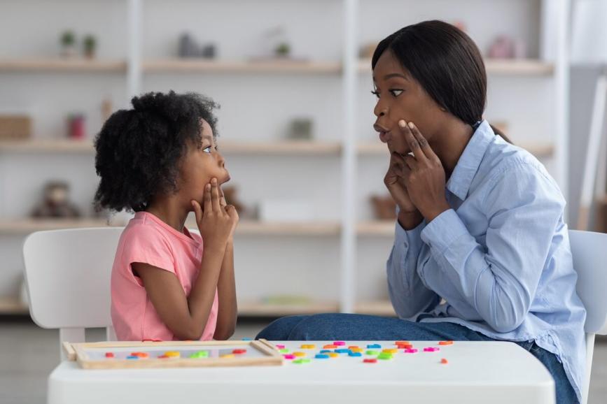 Woman and young girl practicing oral language.