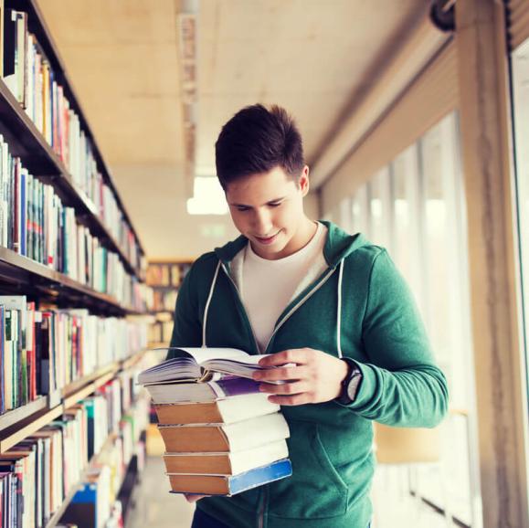 Teen reading a stack of books